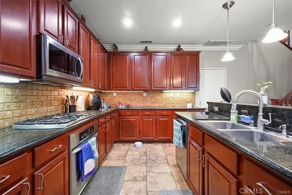a kitchen with stainless steel appliances granite countertop a sink stove and cabinets