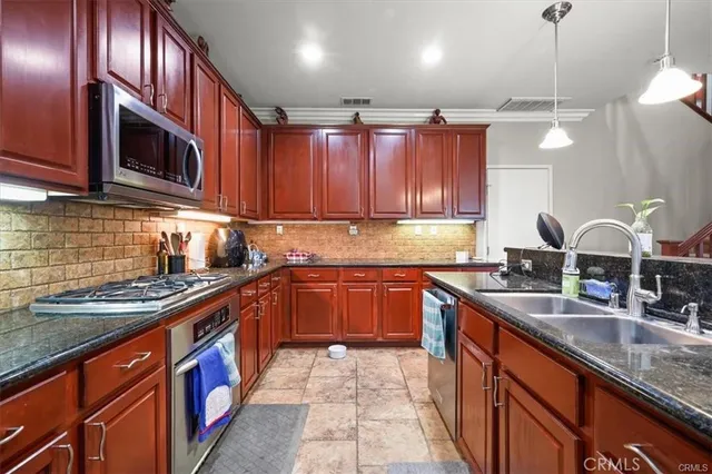 a kitchen with stainless steel appliances granite countertop a sink stove and cabinets