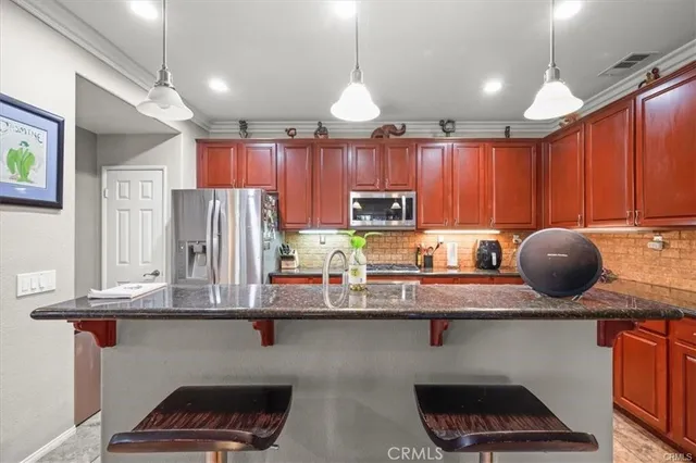 a kitchen with stainless steel appliances granite countertop a sink a stove and a cabinets