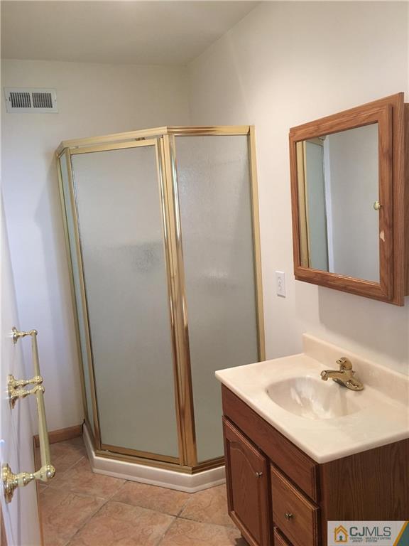 33 Back Drive Edison, NJ 08817 - Photo 12 of 25 a bathroom with a sink a mirror and a vanity