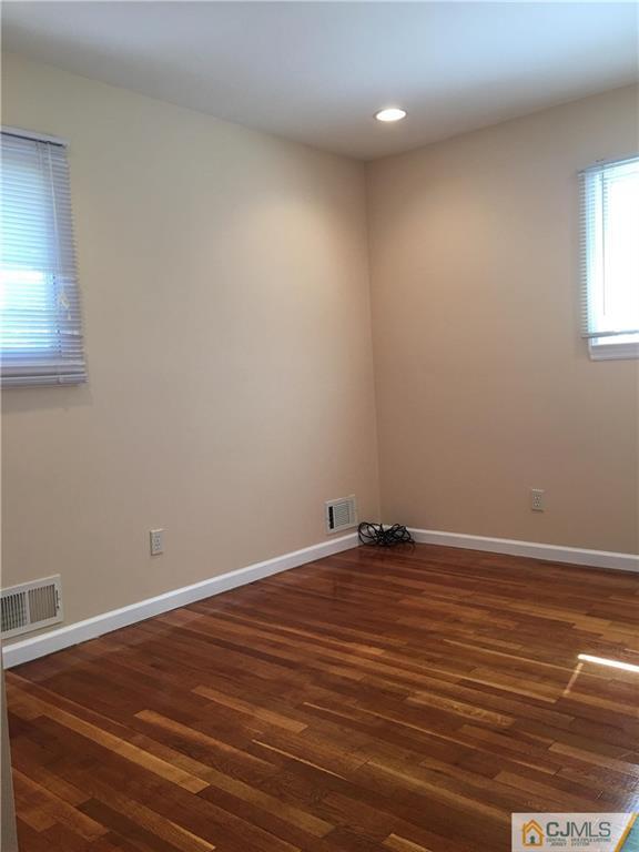 33 Back Drive Edison, NJ 08817 - Photo 15 of 25 a view of an empty room with wooden floor and a window
