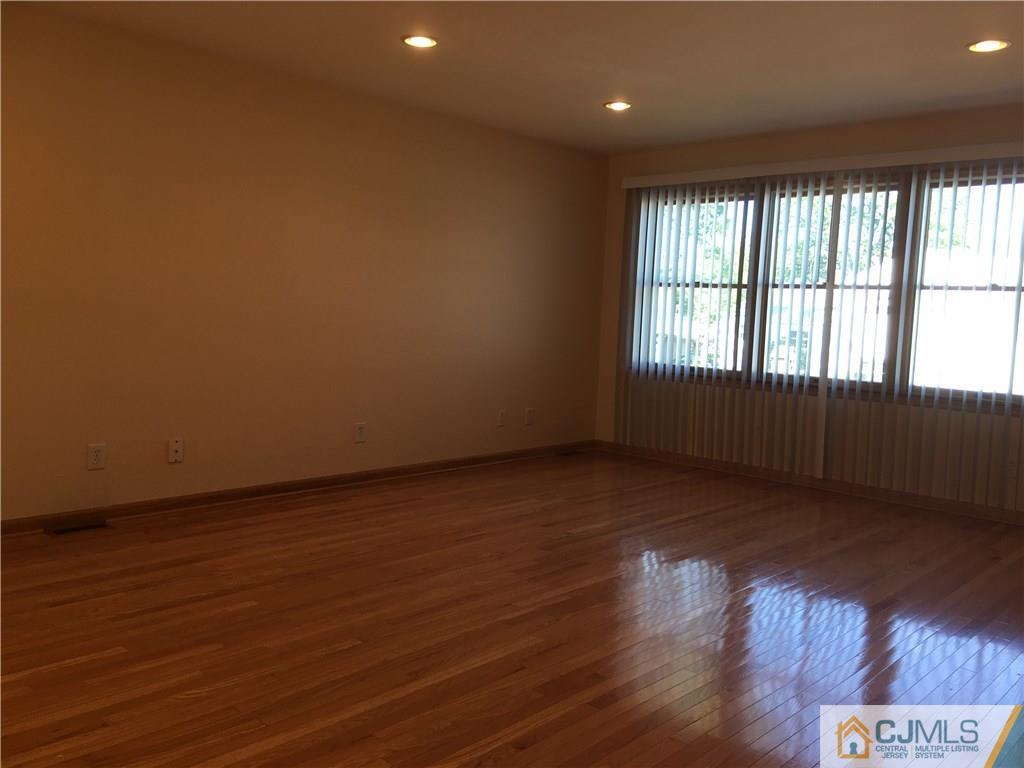 33 Back Drive Edison, NJ 08817 - Photo 19 of 25 a view of an empty room with wooden floor and a window