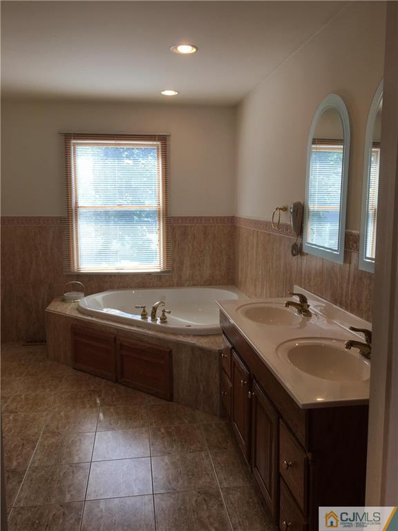 33 Back Drive Edison, NJ 08817 - Photo 21 of 25 a bathroom with a granite countertop bathtub sink and mirror
