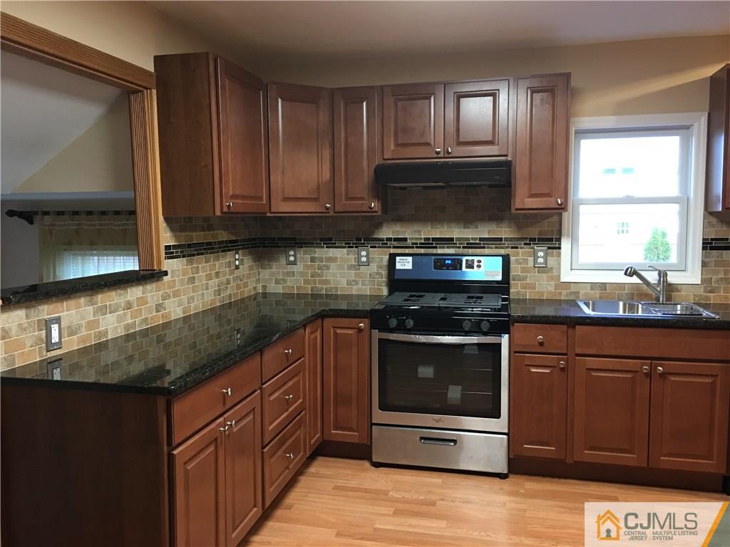 33 Back Drive Edison, NJ 08817 - Photo 5 of 25 a kitchen with stainless steel appliances granite countertop a stove a sink and a microwave