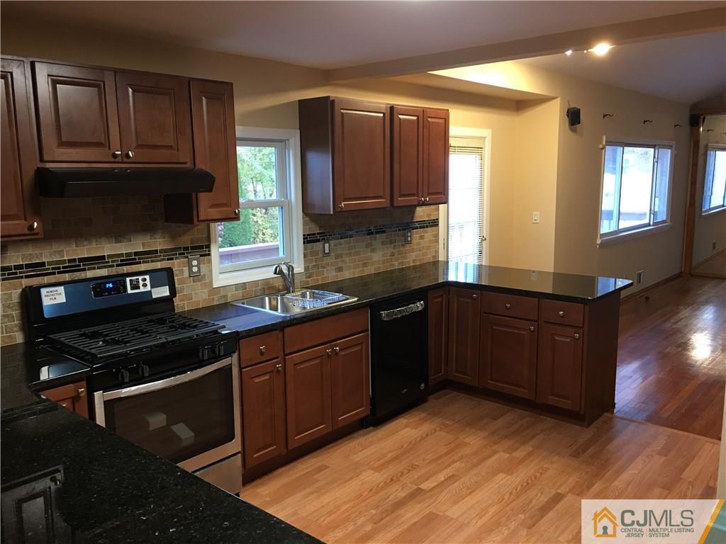33 Back Drive Edison, NJ 08817 - Photo 6 of 25 a kitchen with stainless steel appliances granite countertop a stove a sink and a microwave