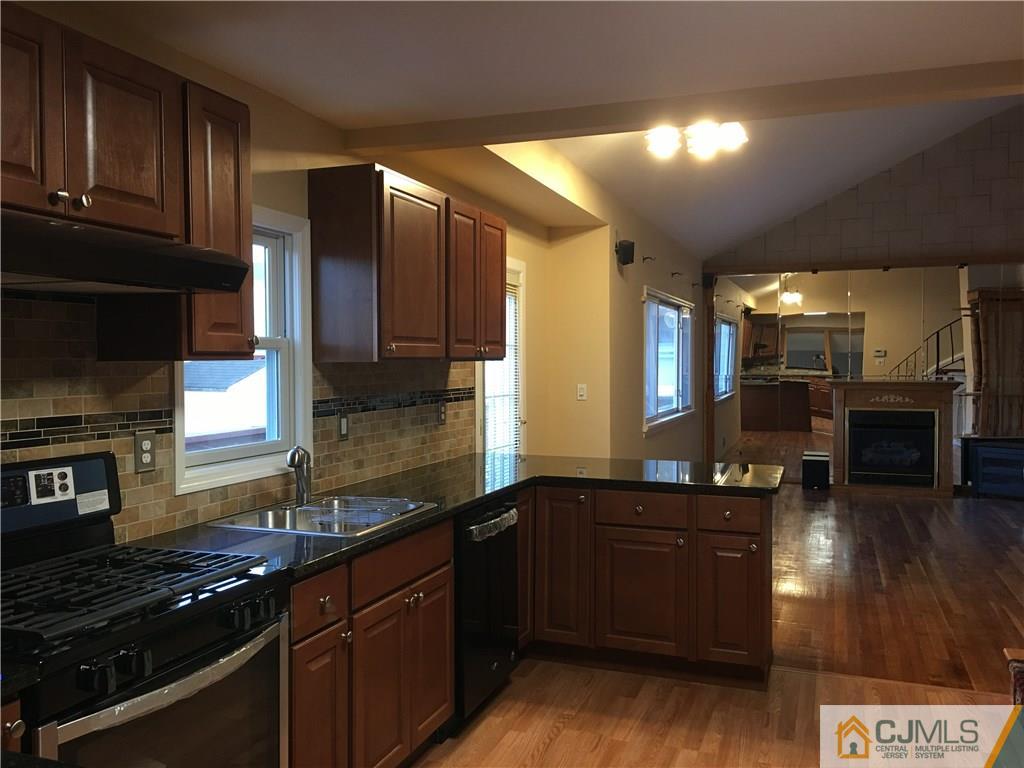 33 Back Drive Edison, NJ 08817 - Photo 7 of 25 a kitchen with stainless steel appliances a sink a stove cabinets and a kitchen island