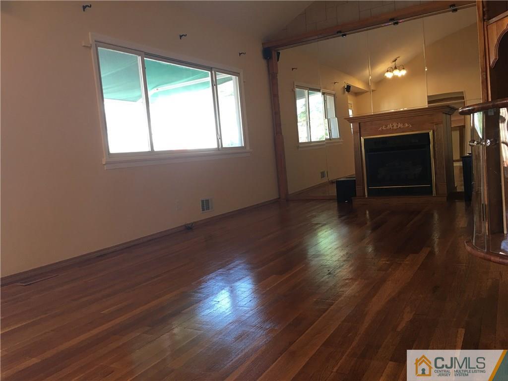 33 Back Drive Edison, NJ 08817 - Photo 8 of 25 a view of an empty room with wooden floor and a window