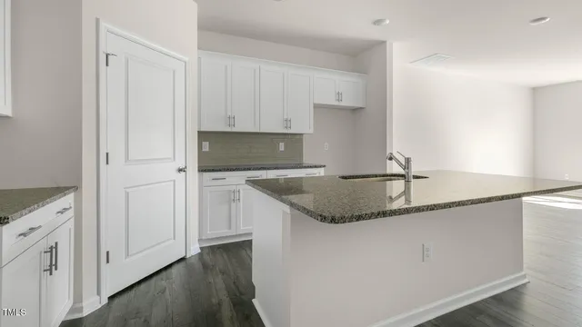 a kitchen with granite countertop a sink and cabinets