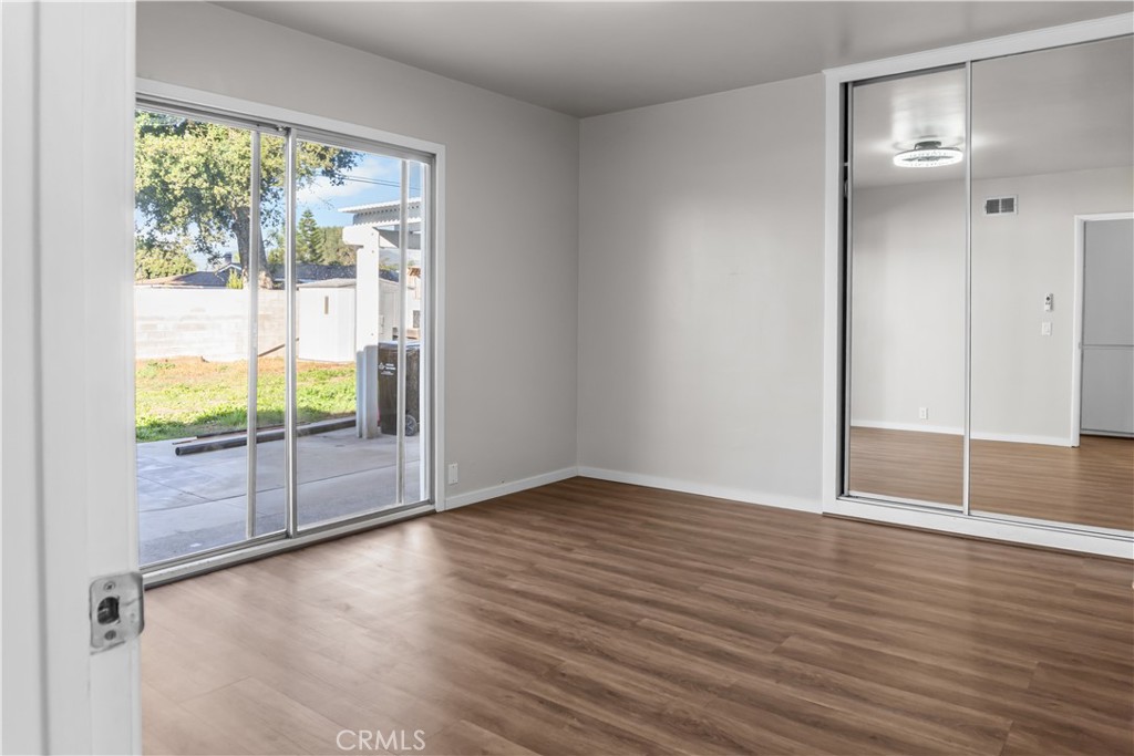 18811 East Weather Road Covina, CA 91722 - Photo 11 of 20 an empty room with wooden floor and door