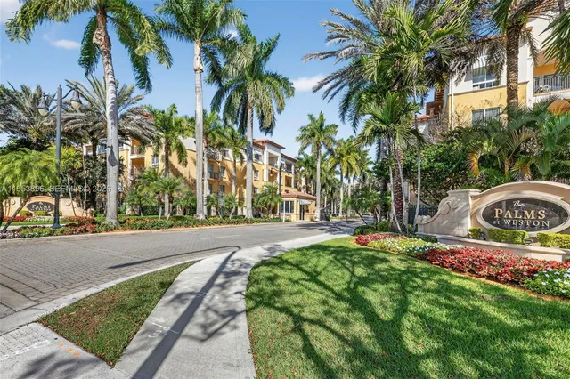 a swimming pool with a yard and palm trees