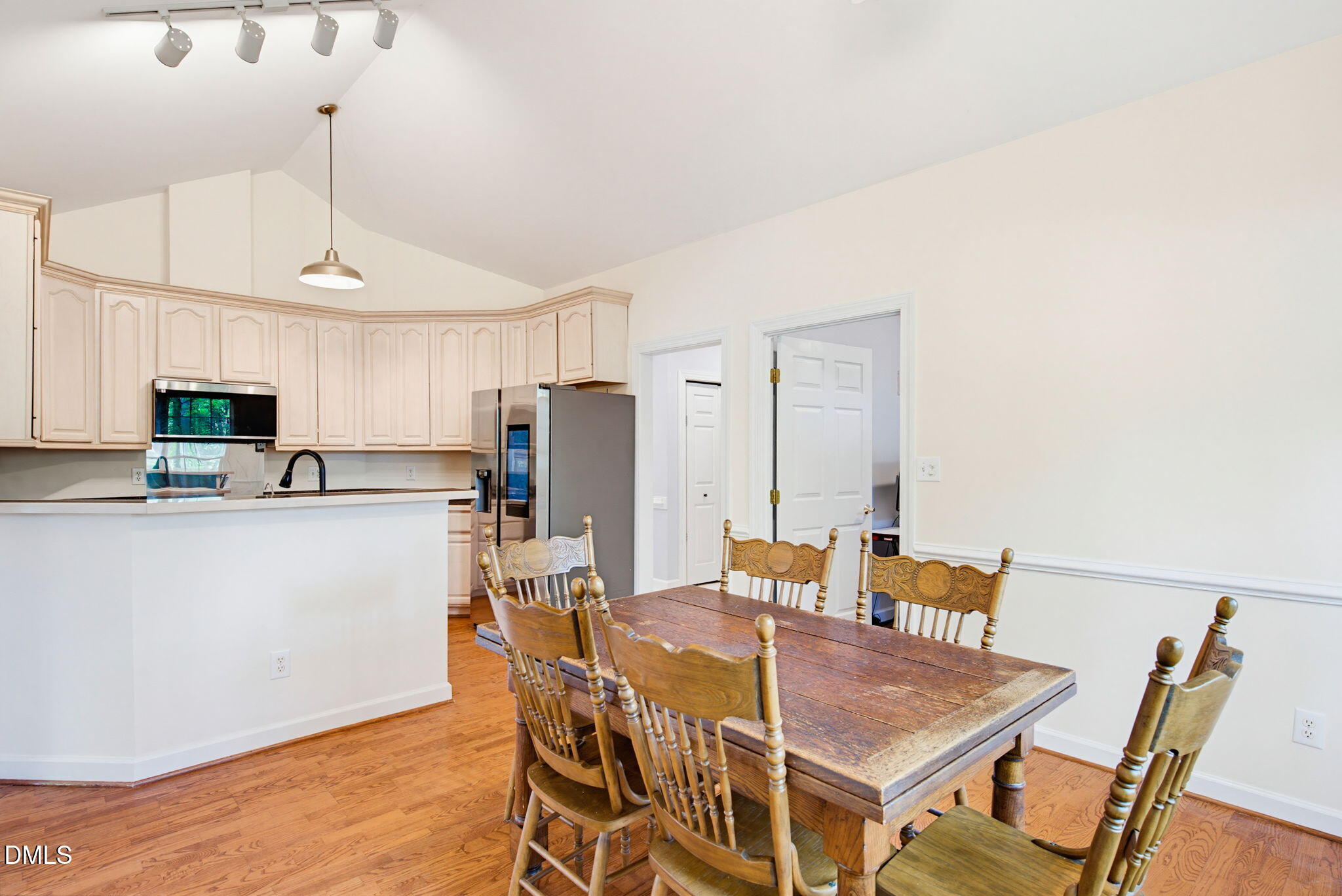 2533 Big Sky Lane Raleigh, NC 27615 - Photo 15 of 40 a kitchen with stainless steel appliances kitchen island granite countertop a dining table chairs and a refrigerator