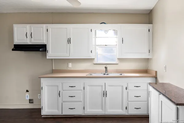 a kitchen with granite countertop white cabinets and white appliances