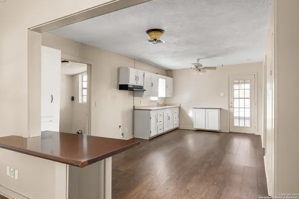 a view of a kitchen with wooden floor and windows