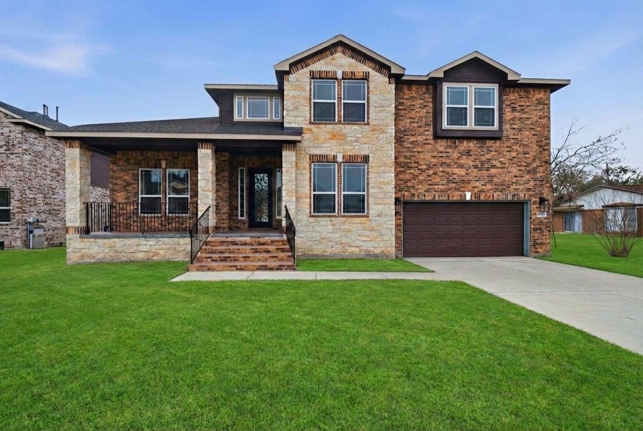 a front view of a house with a garden and yard