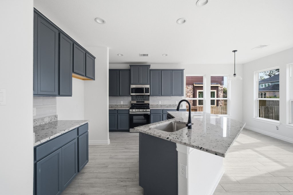 16511 Boston Post Road Cypress, TX 77429 - Photo 12 of 46 a kitchen with stainless steel appliances granite countertop a sink refrigerator and cabinets