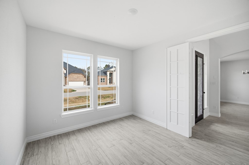16511 Boston Post Road Cypress, TX 77429 - Photo 6 of 46 an empty room with wooden floor and windows