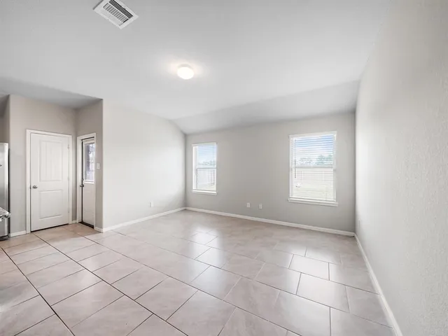 a view of an empty room with window and closet area