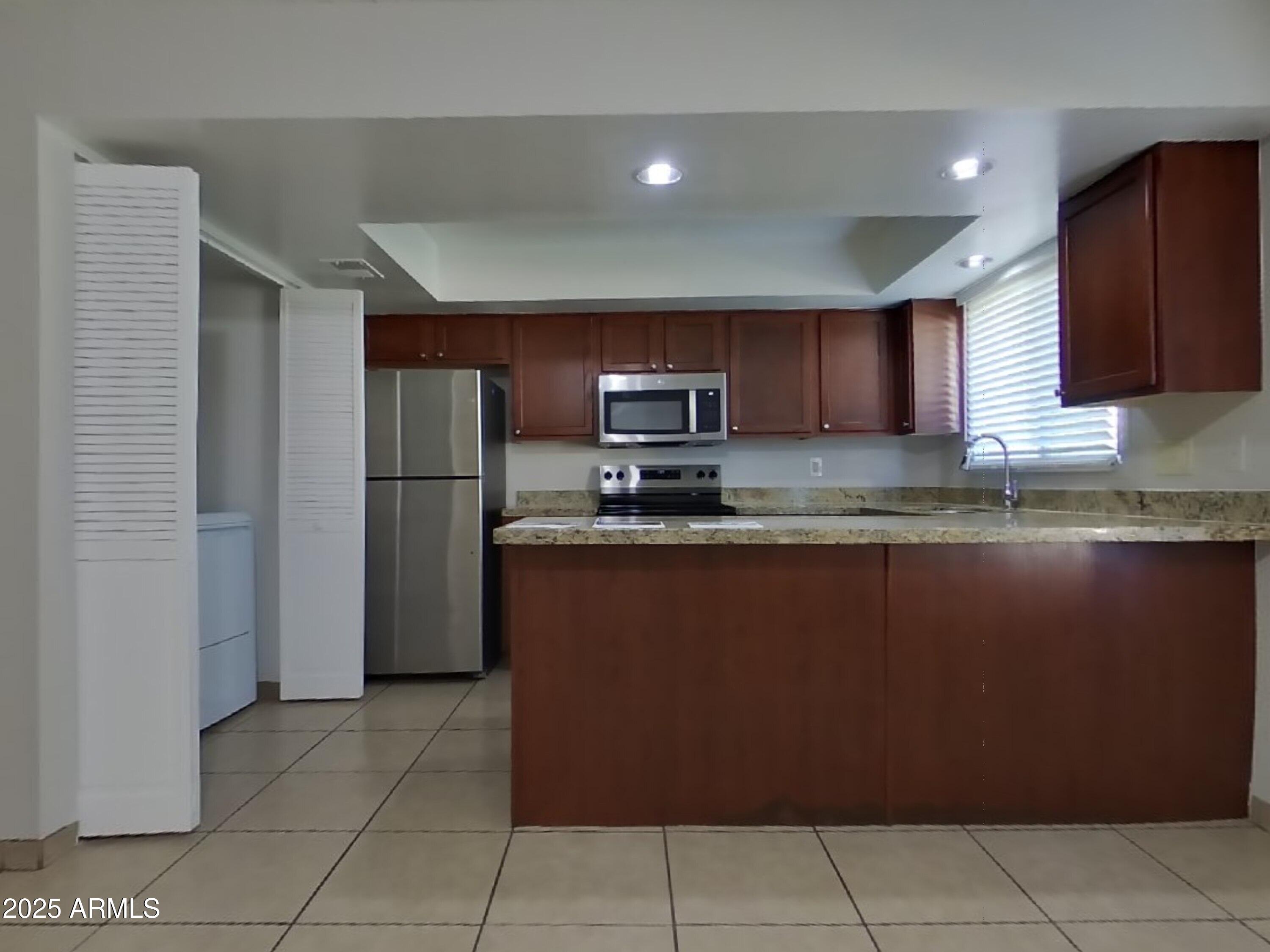 5025 South Mill Avenue Tempe, AZ 85282 - Photo 4 of 18 a kitchen with granite countertop a refrigerator and a stove top oven