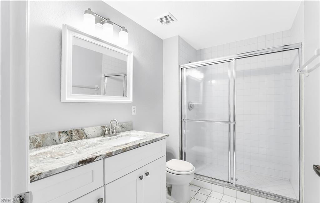 4635 St Croix Lane, Unit 1215 Naples, FL 34109 - Photo 16 of 22 a bathroom with a granite countertop sink toilet and shower