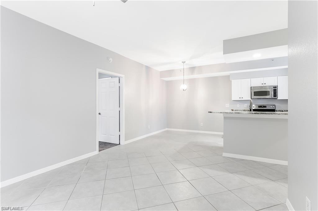 4635 St Croix Lane, Unit 1215 Naples, FL 34109 - Photo 7 of 22 a view of a kitchen with a sink and a refrigerator