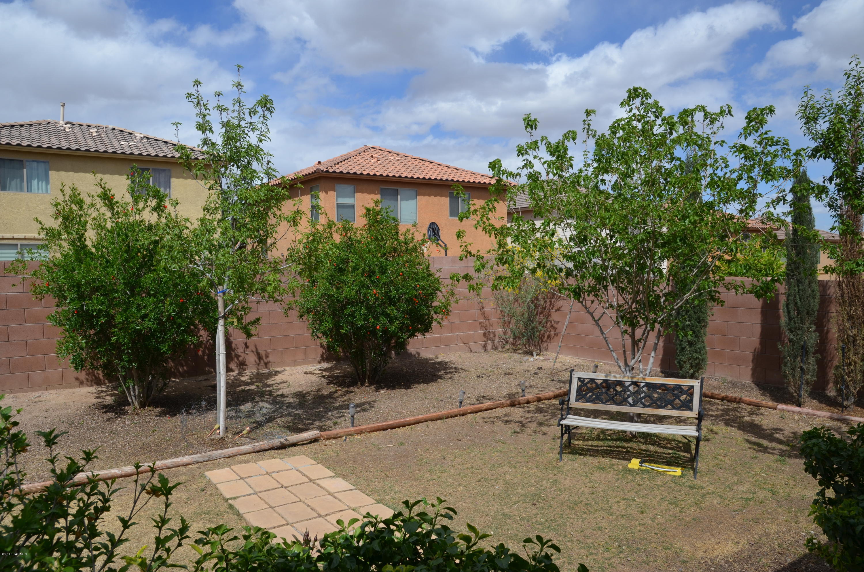 698 West Ash Ridge Drive Green Valley, AZ 85614 - Photo 3 of 19 a backyard of a house with table and chairs under an umbrella