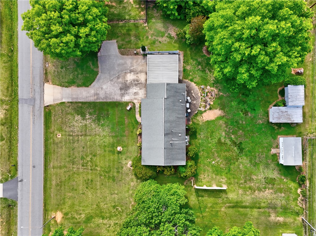 307 Calhoun Road Belton, SC 29627 - Photo 11 of 30 An aerial perspective reveals a vast green landscape with mature trees and a long paved driveway leading to the main residence.