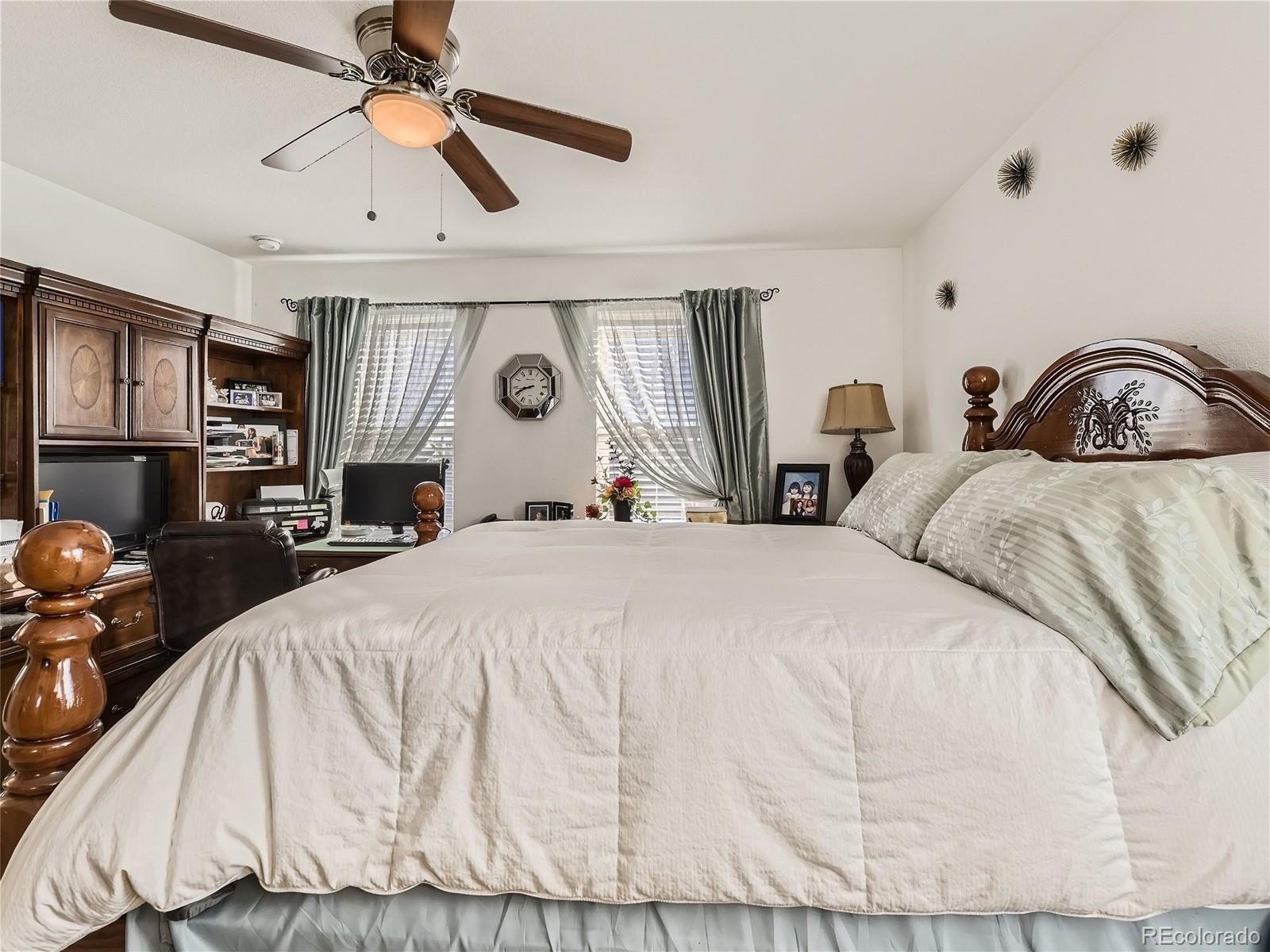 219 South Kellerman Street Aurora, CO 80018 - Photo 16 of 28 a spacious bedroom with a bed a couch and a chandelier