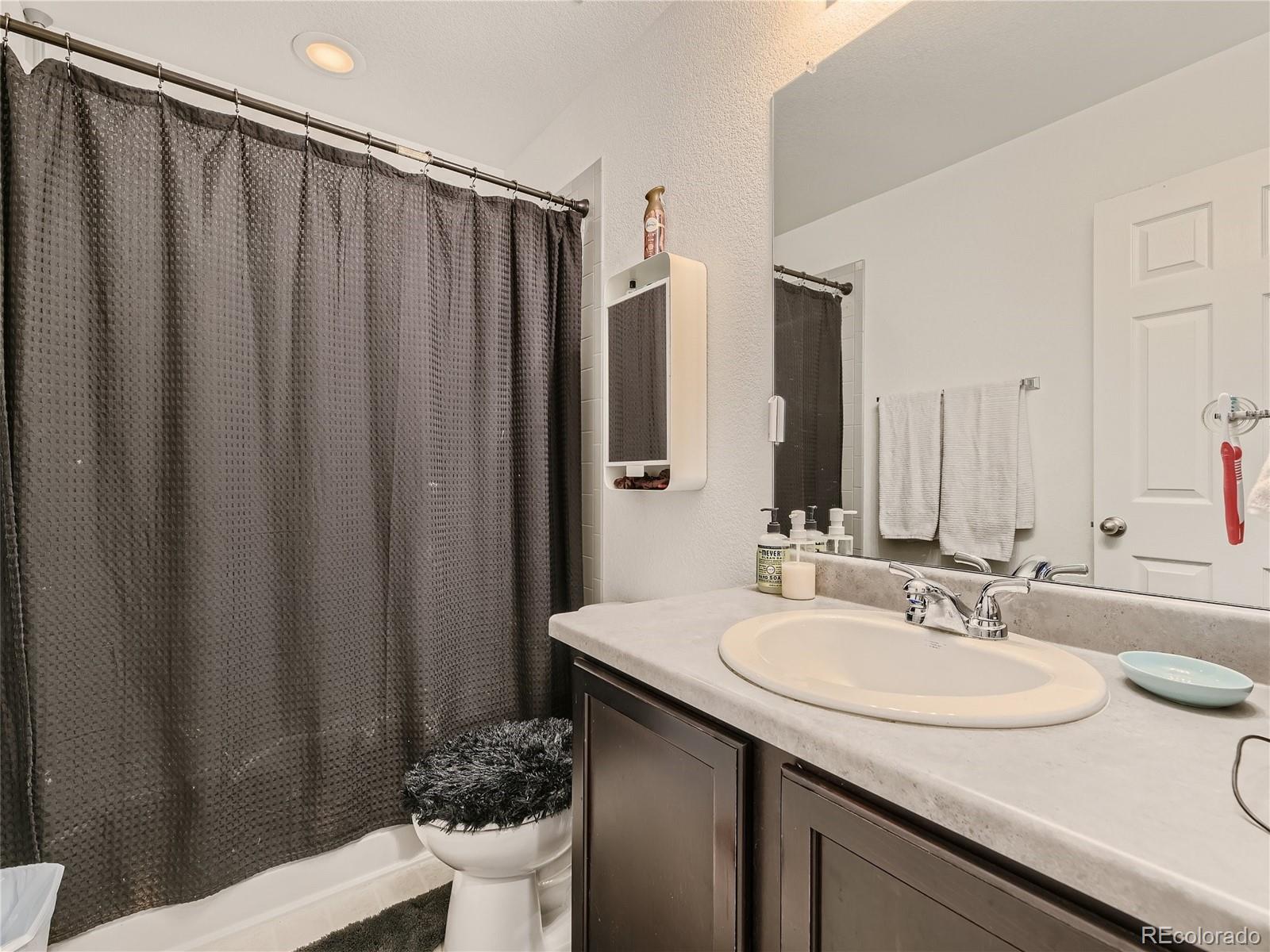 219 South Kellerman Street Aurora, CO 80018 - Photo 22 of 28 a bathroom with a sink and a mirror