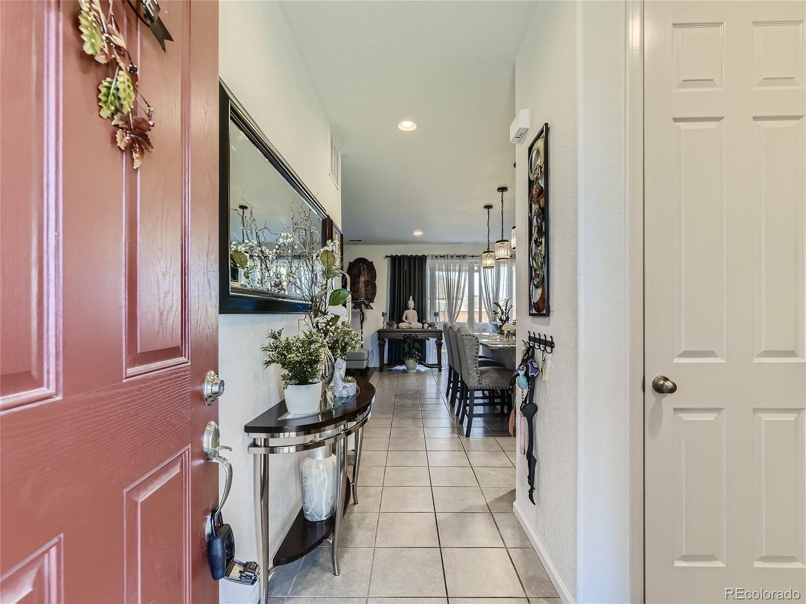 219 South Kellerman Street Aurora, CO 80018 - Photo 5 of 28 a hallway with a dining table and chairs