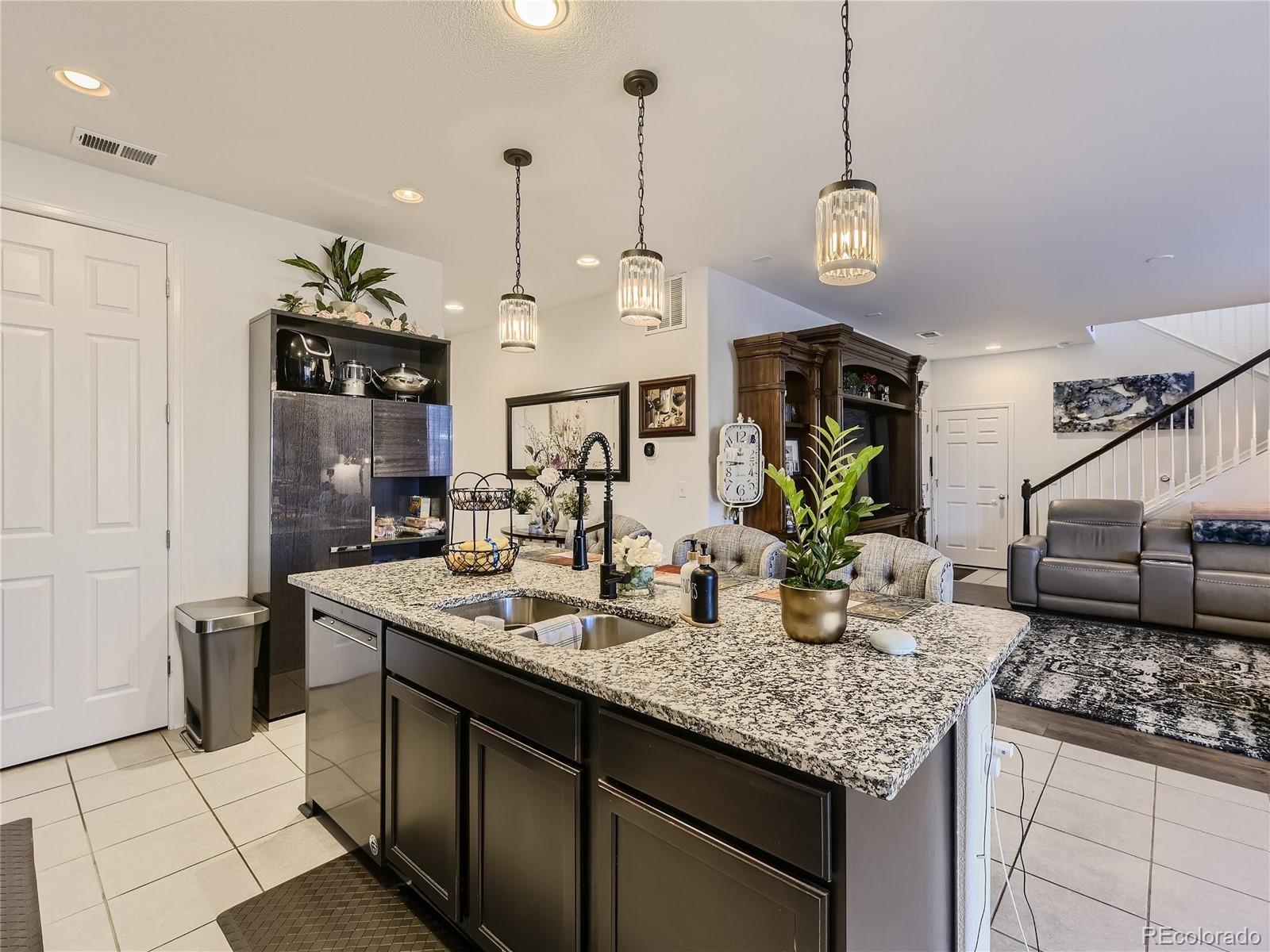 219 South Kellerman Street Aurora, CO 80018 - Photo 10 of 28 a kitchen with granite countertop a sink a stove and cabinets