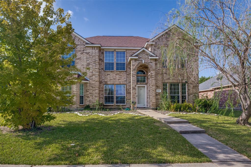 Brick exterior featuring multiple windows and an arched entry