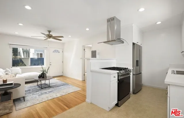 a kitchen with stainless steel appliances granite countertop a stove oven and a refrigerator with white cabinets