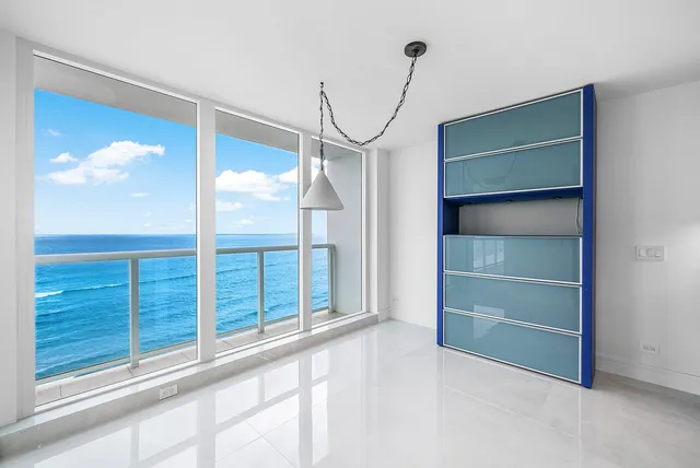 a large white kitchen with a large window a sink and stainless steel appliances