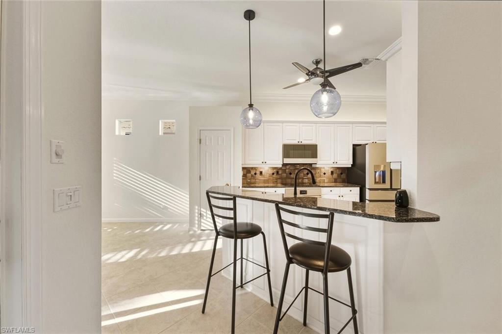7838 Founders Circle Naples, FL 34104 - Photo 11 of 31 a view of a dining room with furniture window and wooden floor