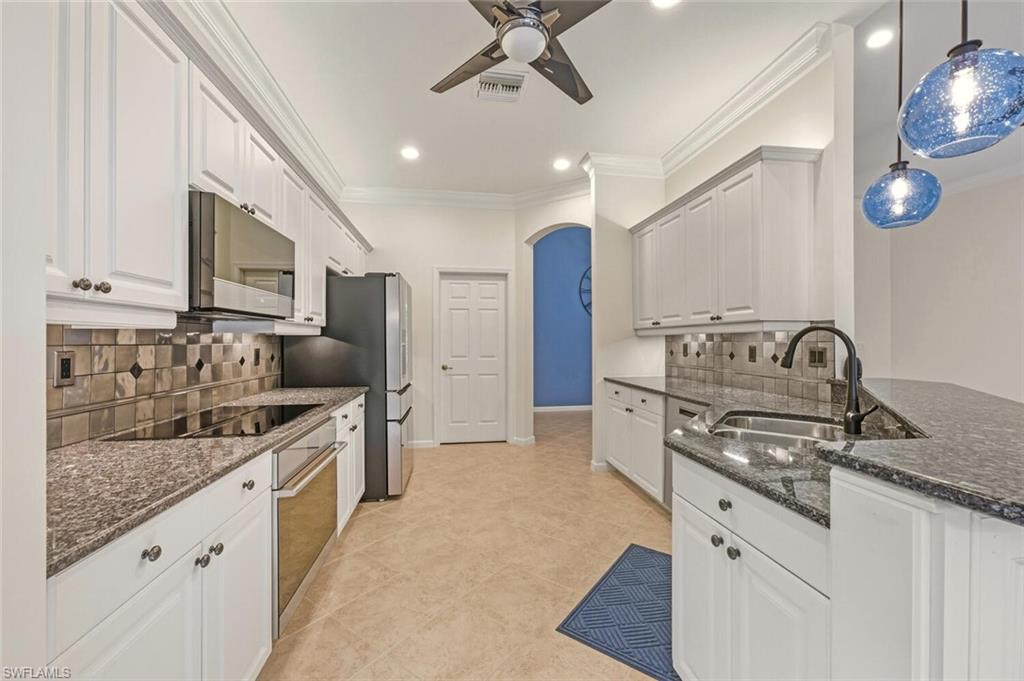 7838 Founders Circle Naples, FL 34104 - Photo 13 of 31 a kitchen with stainless steel appliances granite countertop a sink a stove and cabinets