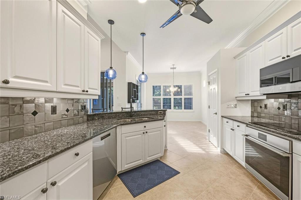 7838 Founders Circle Naples, FL 34104 - Photo 14 of 31 a kitchen with stainless steel appliances granite countertop a sink a stove and cabinets