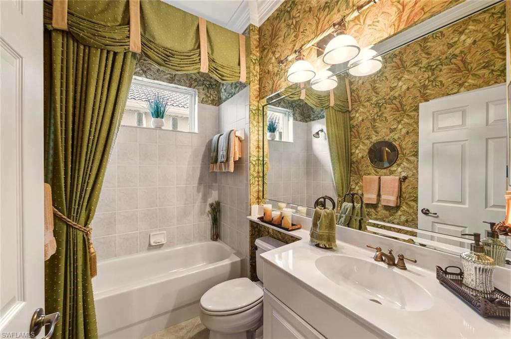 7838 Founders Circle Naples, FL 34104 - Photo 25 of 31 a bathroom with a bathtub sink vanity mirror and toilet