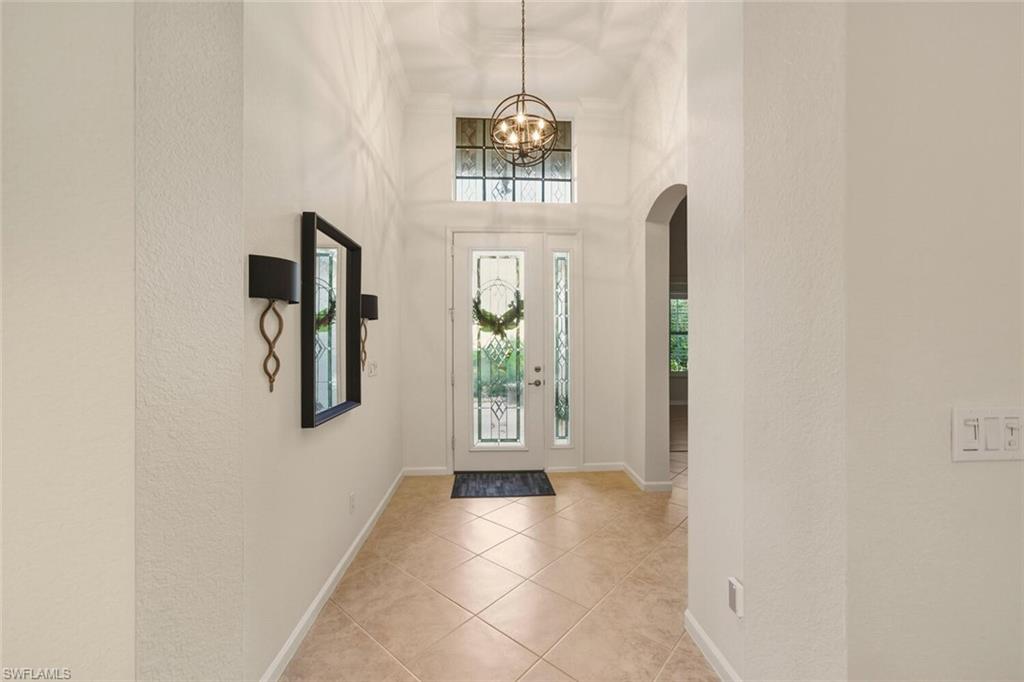 7838 Founders Circle Naples, FL 34104 - Photo 26 of 31 a view of a hallway with windows and chandelier