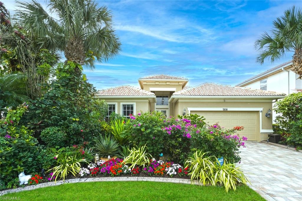 7838 Founders Circle Naples, FL 34104 - Photo 3 of 31 a front view of a house with a big yard and potted plants