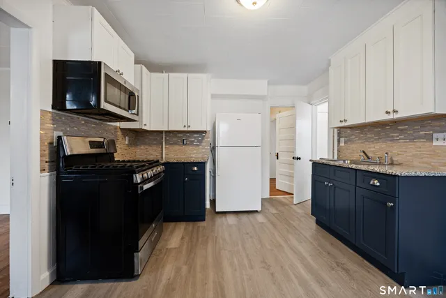 a kitchen with granite countertop wooden cabinets and black appliances