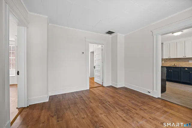 a view of empty room with wooden floor