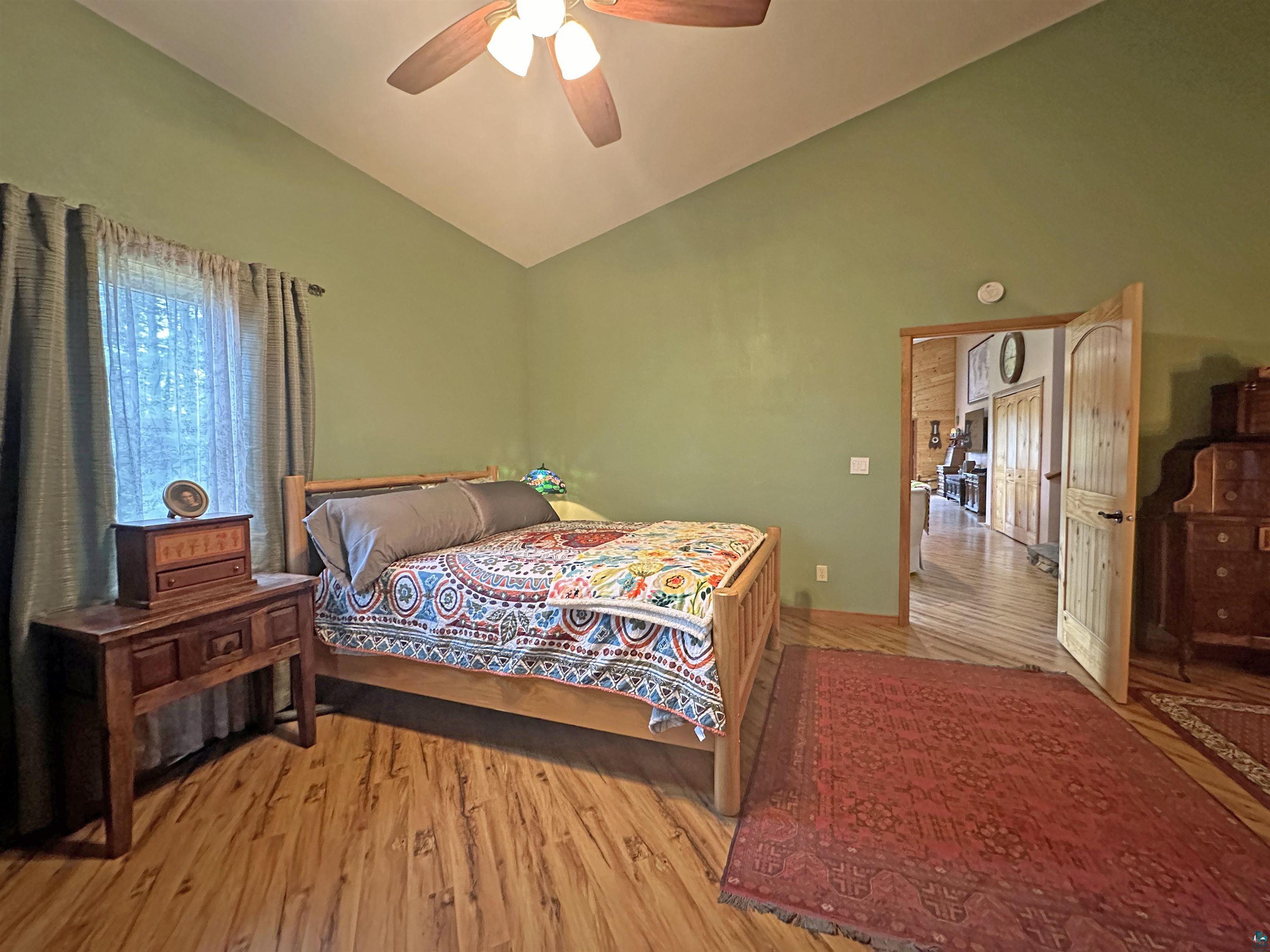 5865 Eastview Road Iron River, WI 54847 - Photo 12 of 41 Bedroom with ceiling fan, lofted ceiling, and light wood-type flooring