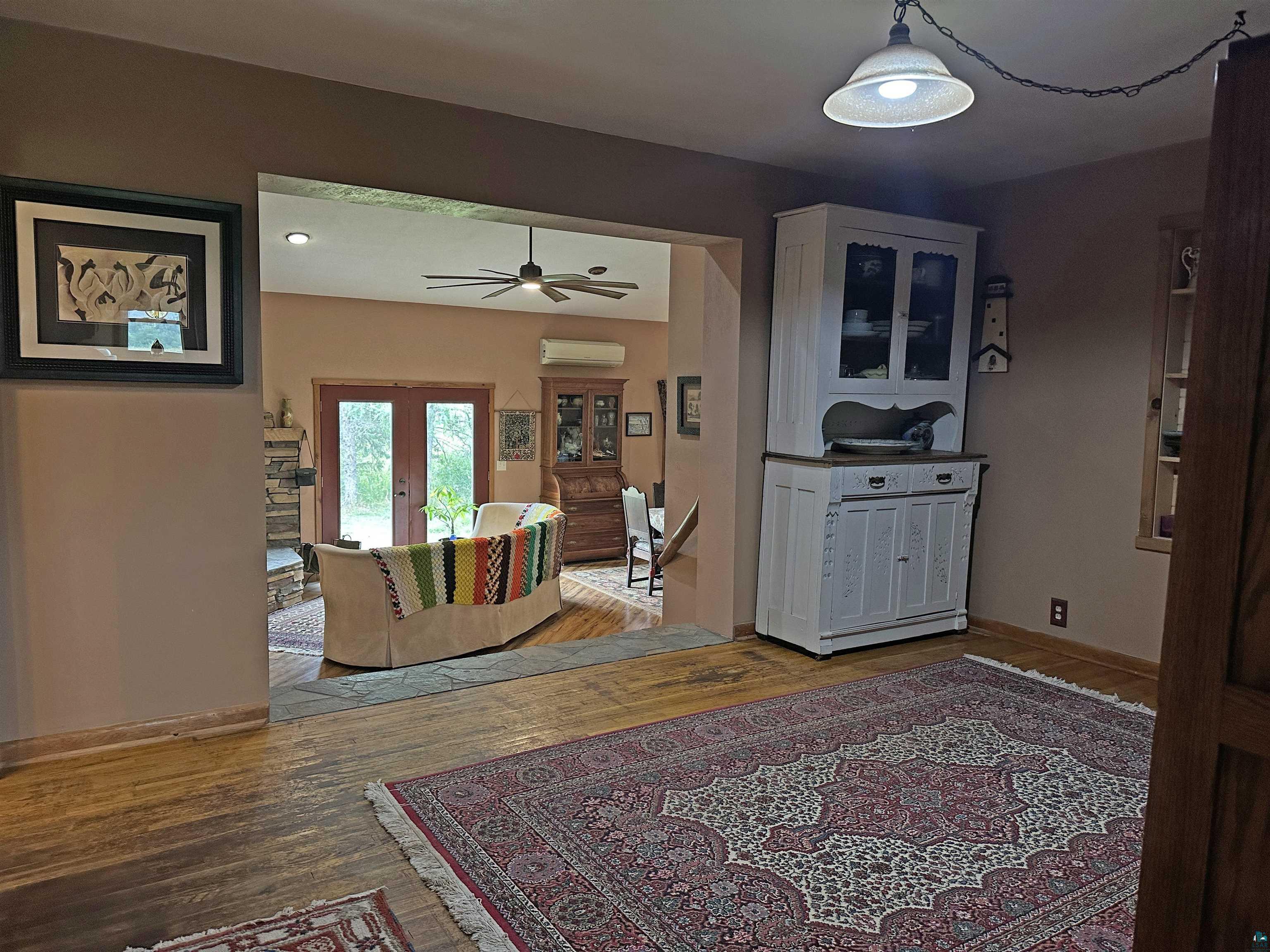 5865 Eastview Road Iron River, WI 54847 - Photo 16 of 41 Living room featuring ceiling fan, french doors, wood-type flooring, and a wall mounted air conditioner