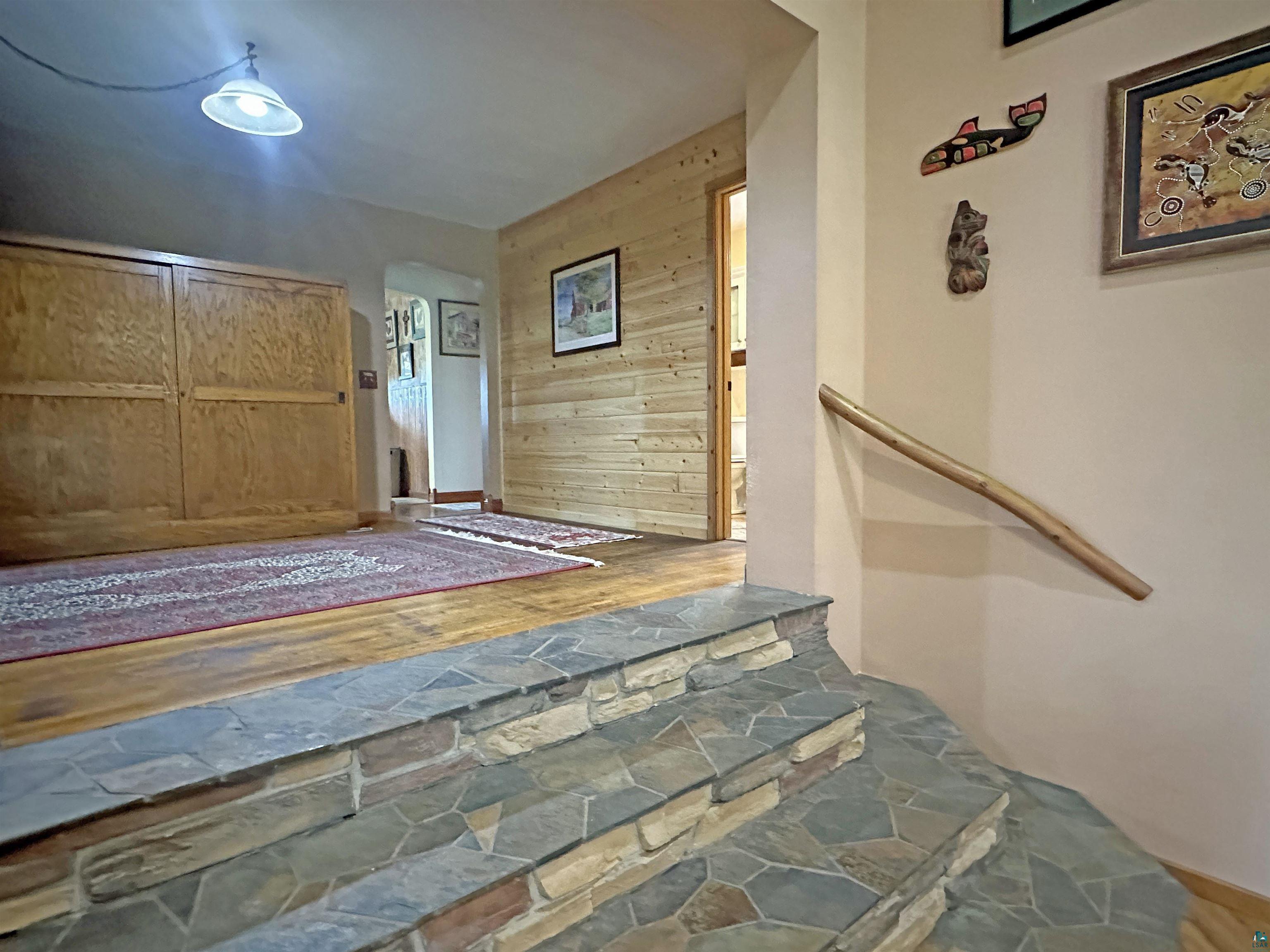 5865 Eastview Road Iron River, WI 54847 - Photo 17 of 41 Stairs featuring wood walls and hardwood / wood-style flooring