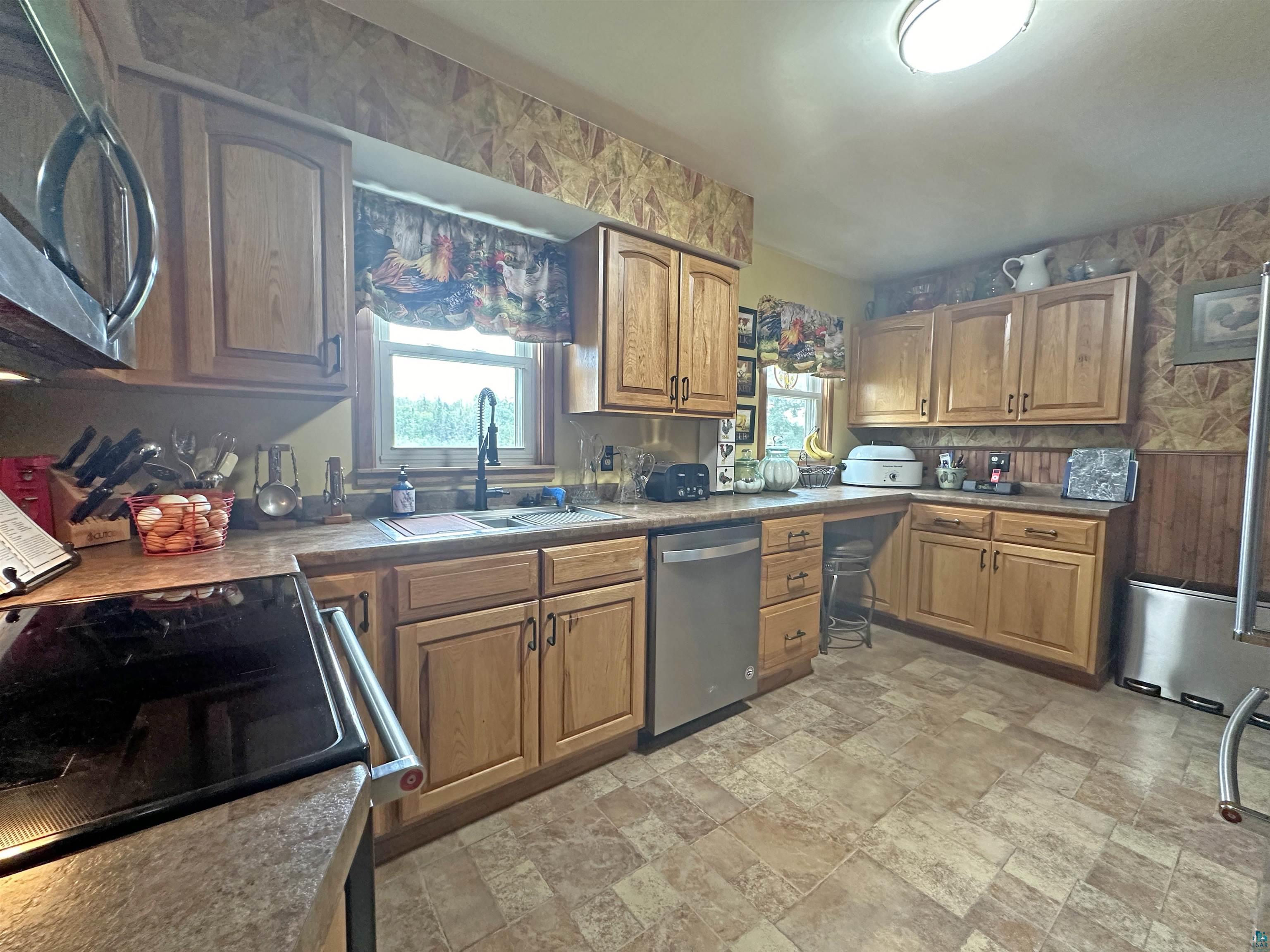 5865 Eastview Road Iron River, WI 54847 - Photo 18 of 41 Kitchen featuring light tile patterned floors, appliances with stainless steel finishes, and sink