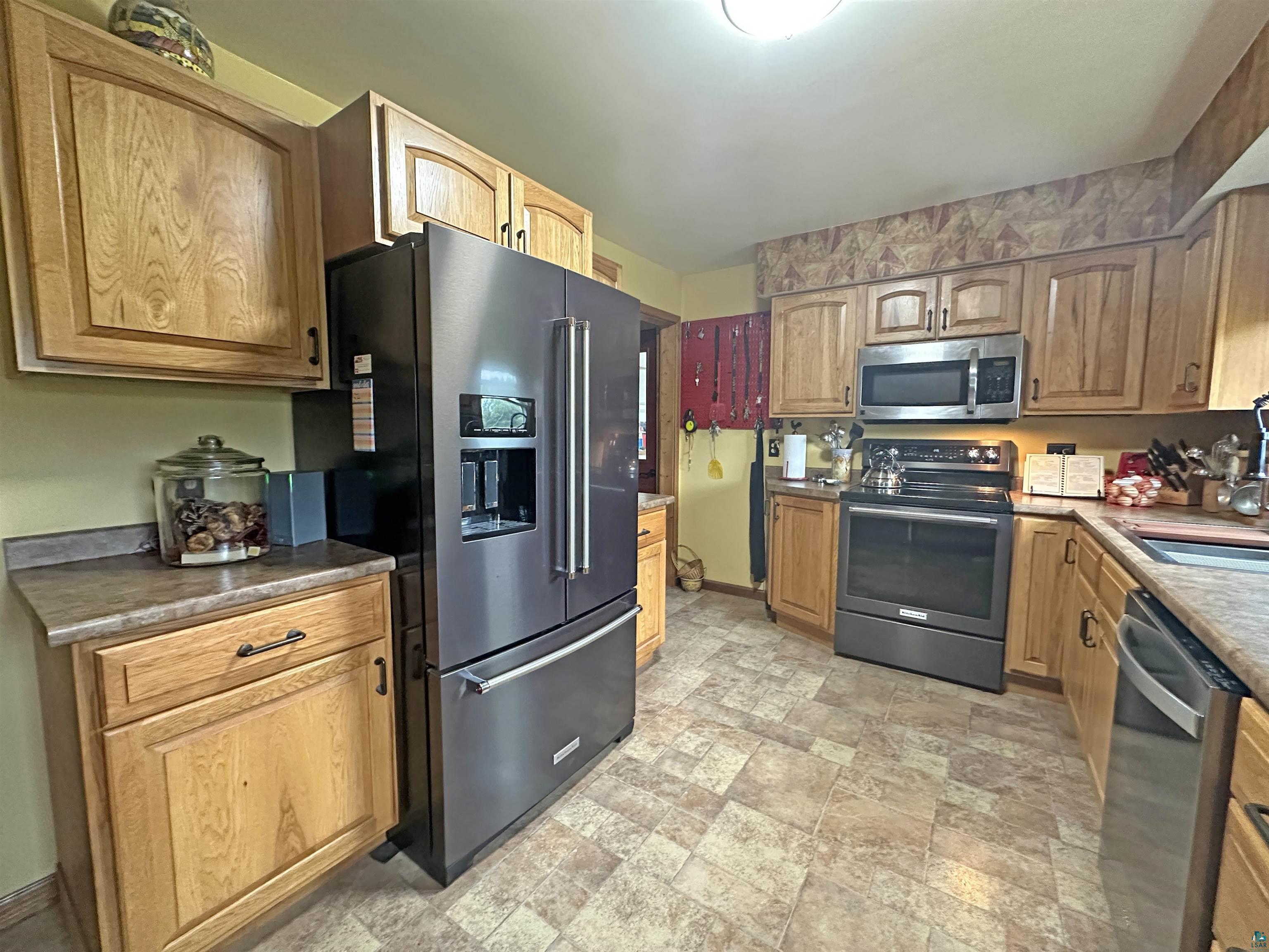 5865 Eastview Road Iron River, WI 54847 - Photo 19 of 41 Kitchen featuring appliances with stainless steel finishes, light tile patterned floors, and sink