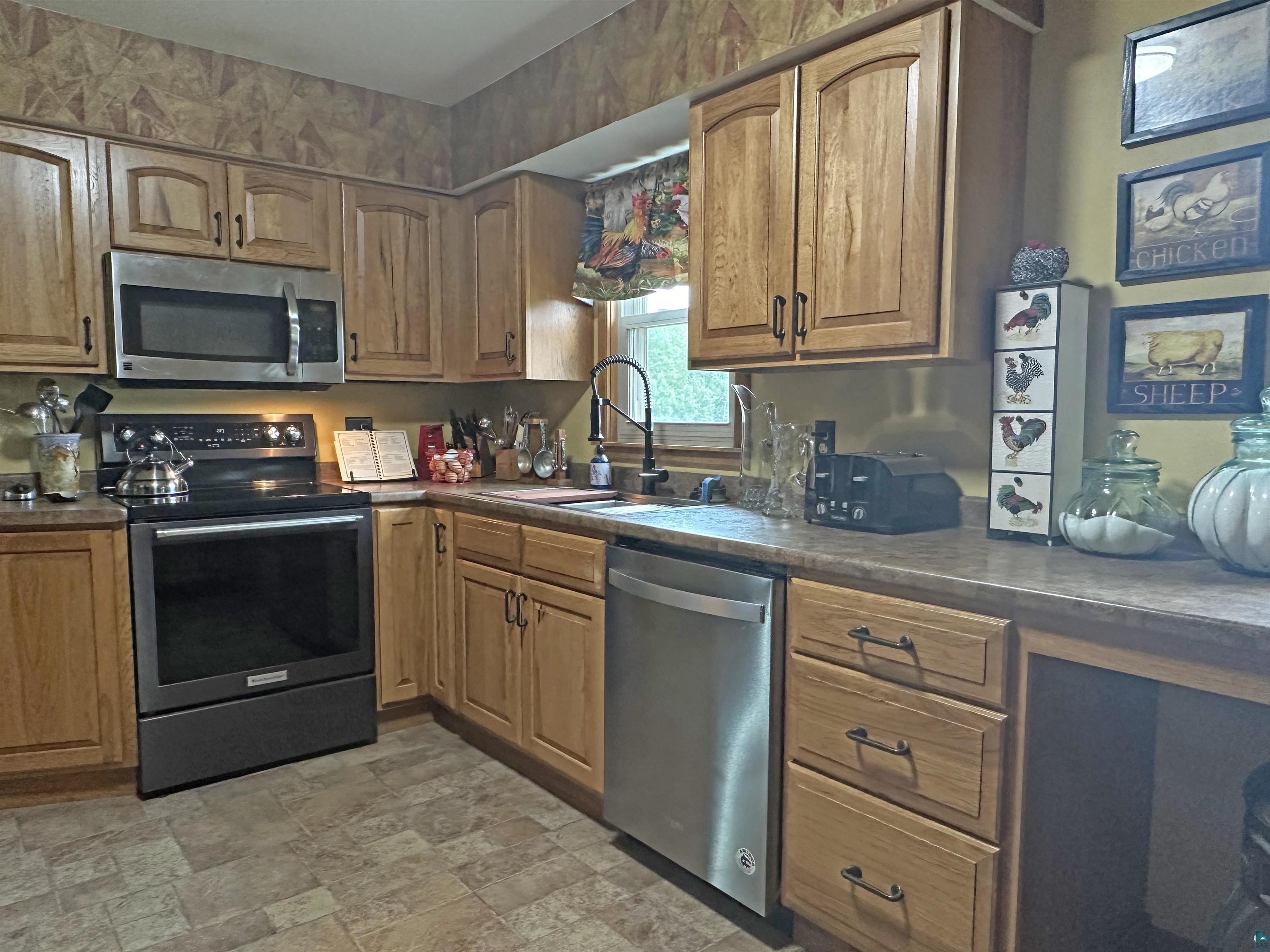 5865 Eastview Road Iron River, WI 54847 - Photo 20 of 41 Kitchen with sink, stainless steel appliances, and light tile patterned flooring