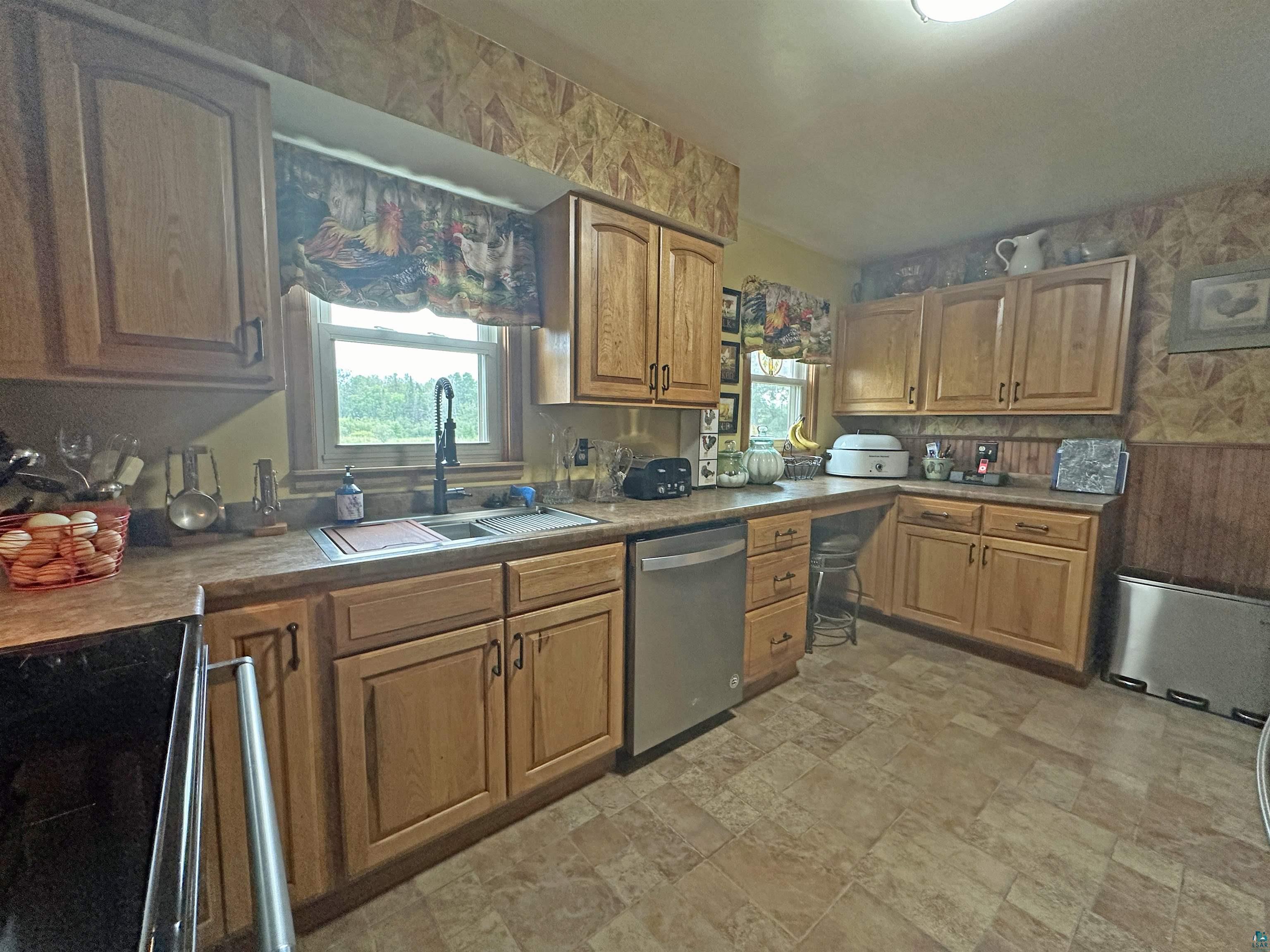 5865 Eastview Road Iron River, WI 54847 - Photo 21 of 41 Kitchen featuring light tile patterned flooring, sink, radiator, and dishwasher