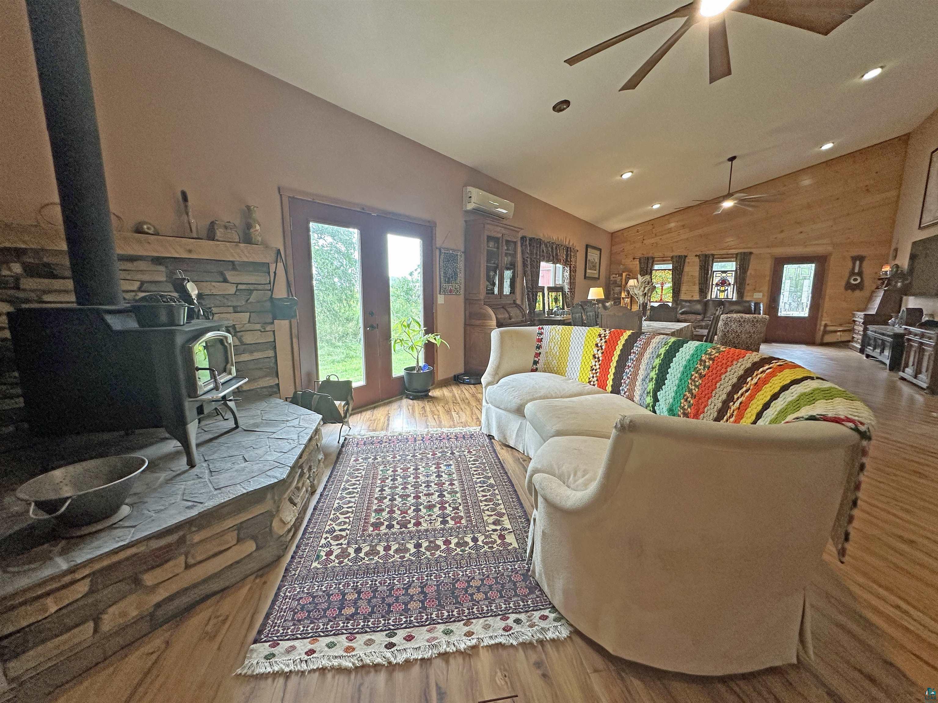 5865 Eastview Road Iron River, WI 54847 - Photo 8 of 41 Living room with ceiling fan, hardwood / wood-style flooring, a wood stove, and lofted ceiling