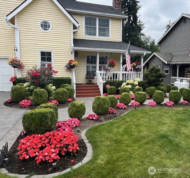 17409 113th Avenue Northeast Bothell, WA 98011 - Photo 7 of 39 a view of a white house that has a yard and flower garden